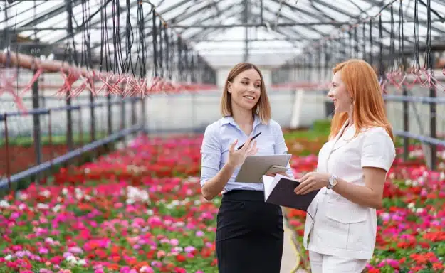 two�business�women having a conversation while visiting greenhouse